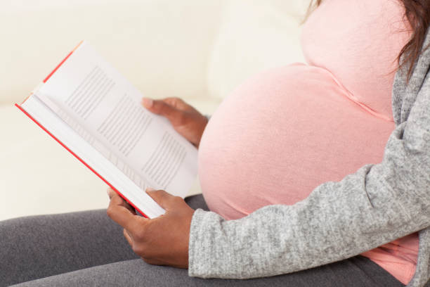 istock Relaxed pregnant woman reading a book. 679939146