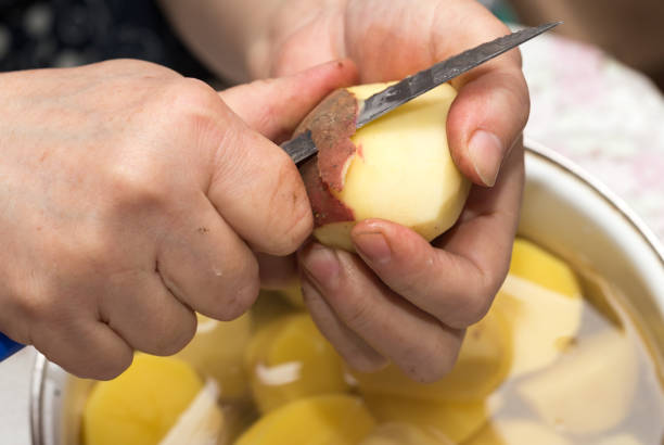 istock The cook cleans the potatoes with a knife 679940278