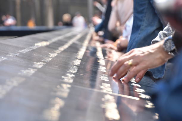 national september 11 memorial in manhattan, menschen berühren sie die namen der angehörigen - people traveling business travel travel new york city stock-fotos und bilder