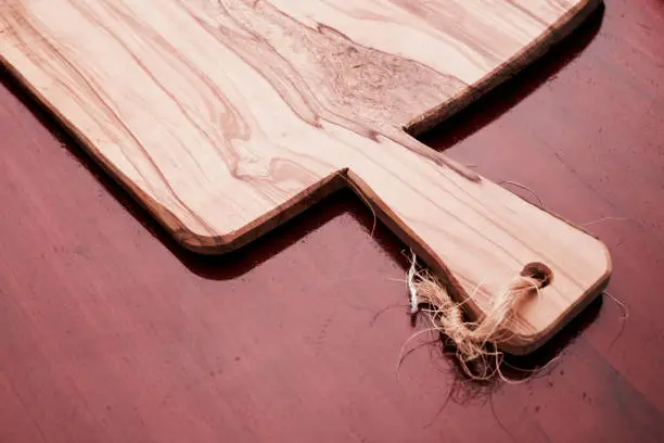 elegant olive-wood cutting board on a wooden table