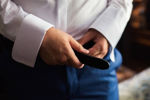 istock man corrects belt, fees groom, man's hands, dressing, man buttons pants, jeans 679966536