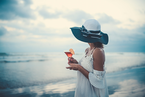 Female Drinking Cocktail and Enjoying the Sunset Ocean View
