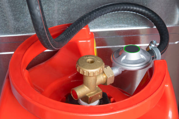 a hose connected to the cylinder red gas supply - botija de gas imagens e fotografias de stock