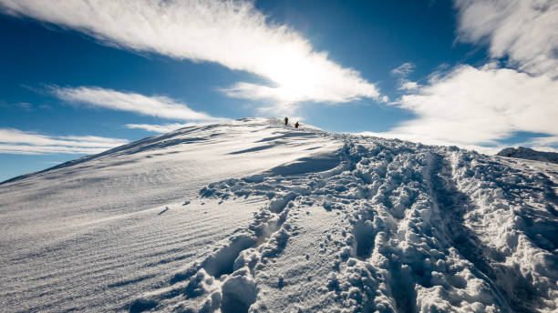 istock tourists enjoying high mountains in snow on a sunny day 679975544