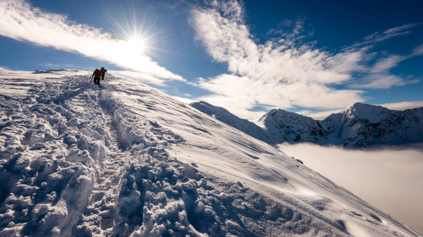 istock tourists enjoying high mountains in snow on a sunny day 679975558