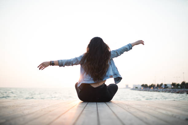 istock Young woman sitting looking sunset 679984314