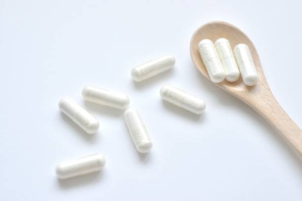 istock White supplement pills on wooden spoon 679990472