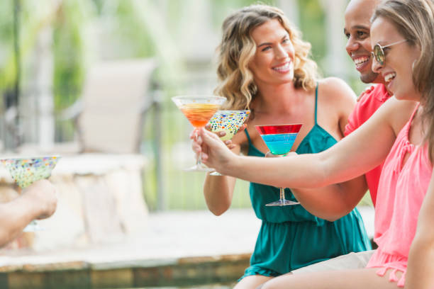 istock Multi-ethnic adults at party with cocktails, toasting 679990792