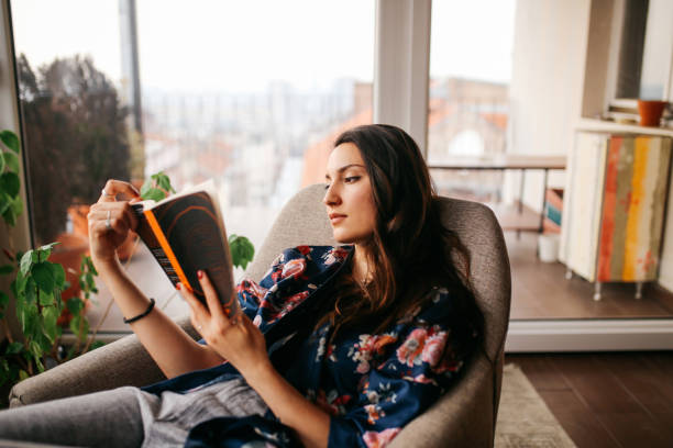 istock Young woman reading at home 679994716