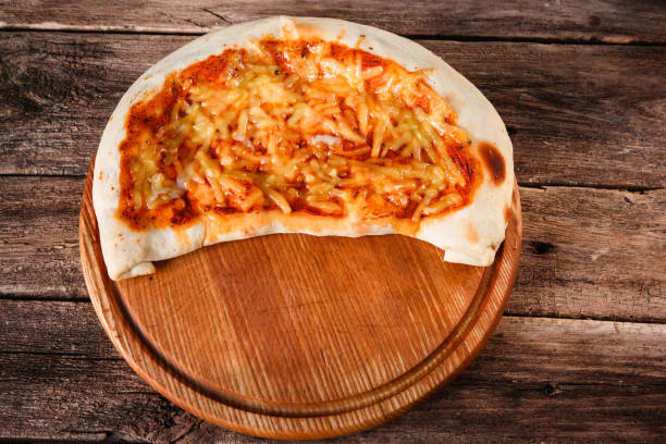 istock Italian pizza calzone served on wooden platter 680022746