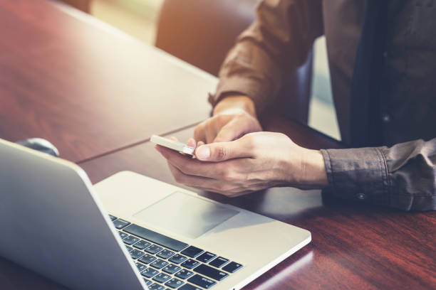 istock business man hand holding and using smartphone in the office. 680024104