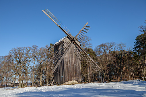 Antique wooden windmill. Winter contryside scene.