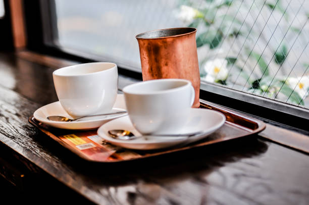 istock two empty cups of hot chocolate or coffee cappuccino on the table in cafe, coffee and drinks close up 680028524