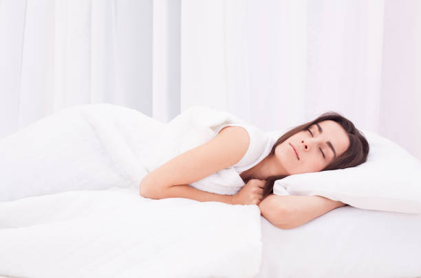 istock Beautiful young woman sleeping in white bed 680053960