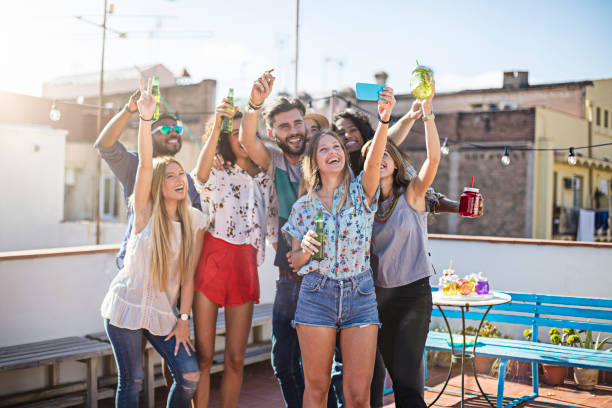 istock Friends with beer bottles taking selfie on terrace 680056412