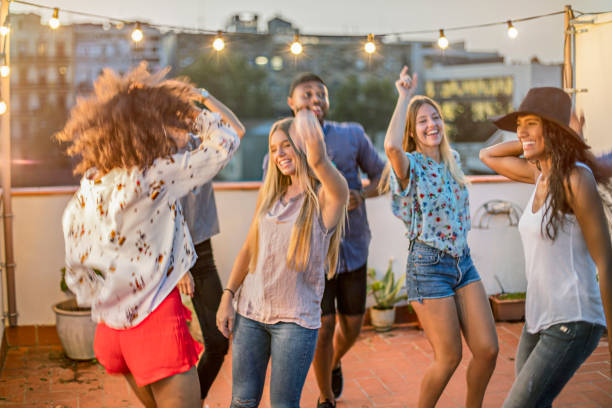 istock Happy friends dancing while enjoying terrace party 680056458
