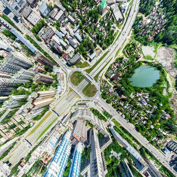 Aerial city view with crossroads and roads, houses, buildings, parks and parking lots. Sunny summer panoramic image - fotografia de stock