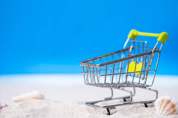 istock miniature shopping cart on tropical white sand beach. 680058384