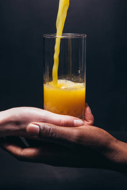 istock Black and white hand hold glass with juice closeup 680059436