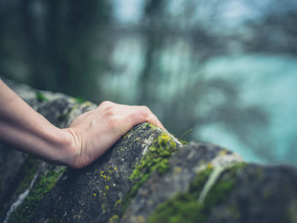 istock Female hand resting on stone wall 680059710