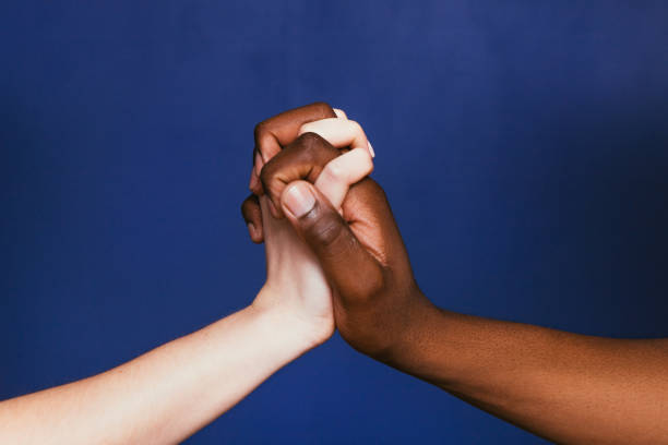 istock White and black hands clasped together, close up 680062136