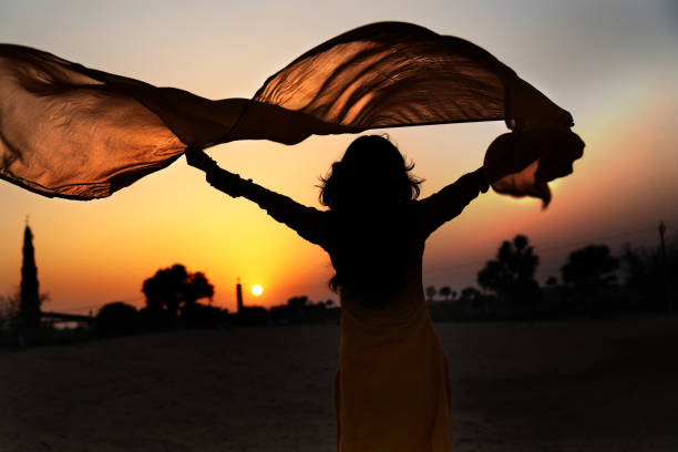 Women silhouette in the nature Beautiful young woman holding yellow scarf on the wind. ariel west bank stock pictures, royalty-free photos & images