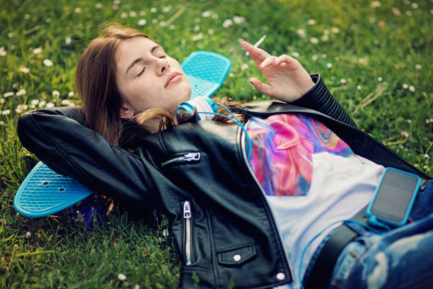 istock Teenage girl is lying down and smoking cigarette 680068164