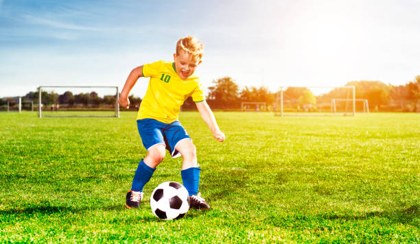 istock Boy makes a dribbling with soccer ball and gets ready to kick 680068668