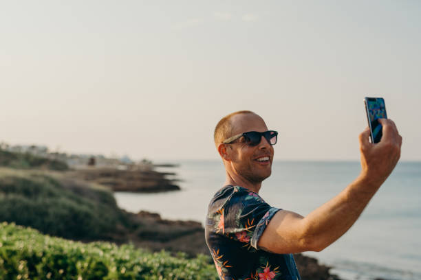 istock Man on vacation taking photo or selfie with smart phone 680071666