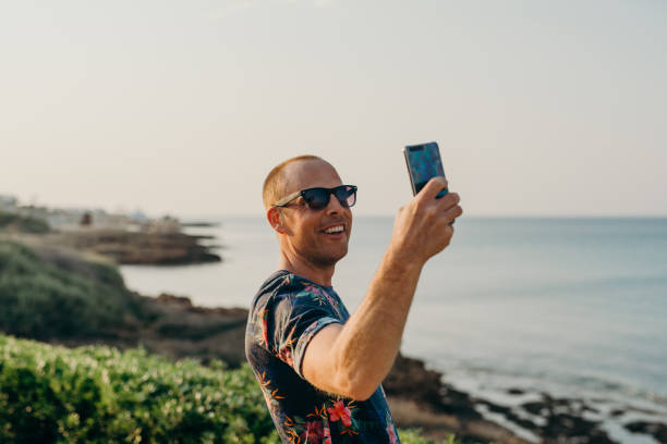 istock Man on vacation taking photo or selfie with smart phone 680071912