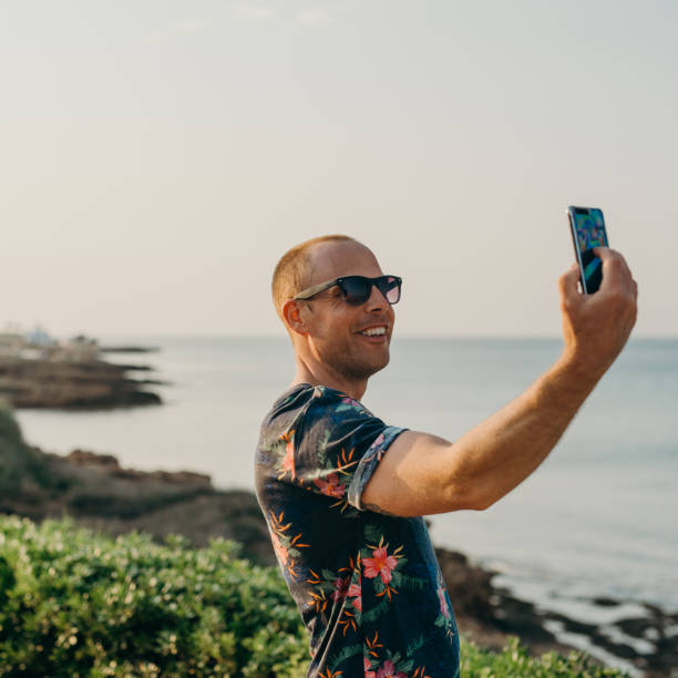 istock Man on vacation taking photo or selfie with smart phone 680072144
