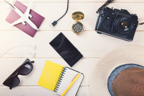 istock ready for vacations - travel essentials on white wooden background 680072826