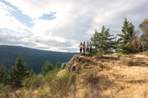 Eurasian teenager with extendedf family looking down from top of mountain.  Sooke (Victoria), British Columbia, Canada\n\n\n\n