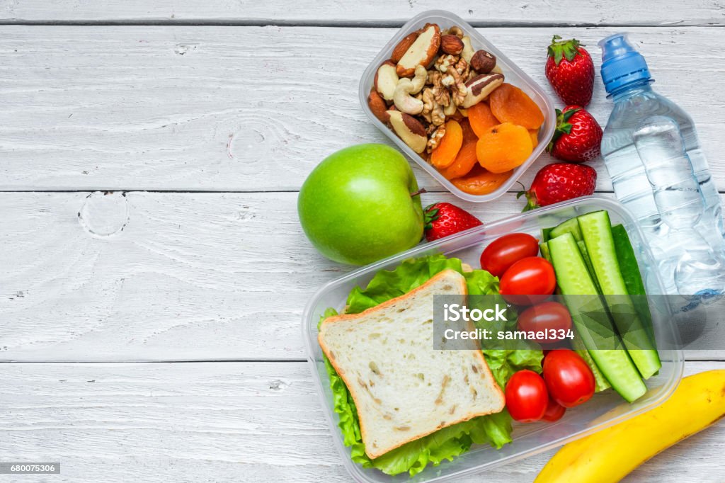 boîtes à lunch école avec sandwich et légumes frais, bouteille d’eau, de noix et de fruits - Photo de Gamelle libre de droits