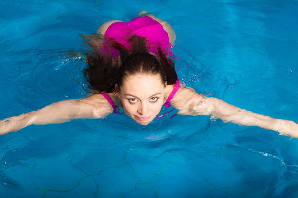 istock Beautiful woman swimming in pool 680079054