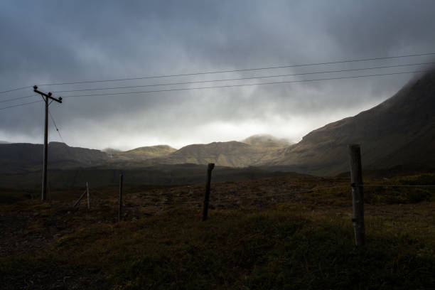 istock Power pole in Iceland. Light and shadow over the landscape. Beautiful mountain range in the backgrond. Tough nature. 680081010