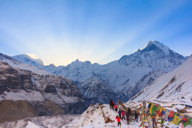 молитвенные флаги и снежная гора базового лагеря гималаев аннапурна, непал - annapurna range стоковые фото и изображения