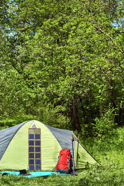 istock Camping on a glade in the forest with a backpack and tent. 680092548