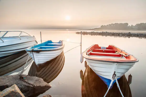 Photo of Wooden boat moored at quay. Sunrise scenery.