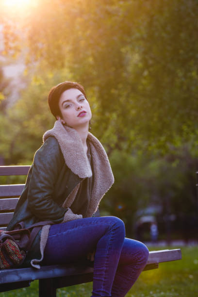 istock Young and smiling girl sitting on a park bench 680093822