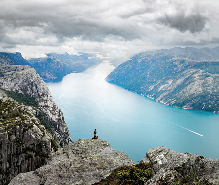 Beautiful landscape on Lysefjord viewing from  hiking trail to Preikestolen, famous nature landmark in Norway. Lysefjorden, dramatic cloudy sky and mountains in background.