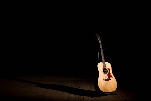 istock Acoustic guitar over dark background standing position with copy space 680100574