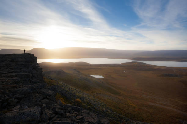 istock Hiker on a rocky cliff during the sunset. Great atmosphere with light and a spectacular perspective. Tough nature in Iceland. 680100648