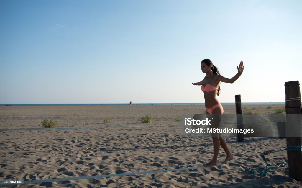 Balancing on slackline Woman walking on slackline at the beach Montenegro Stock Photo
