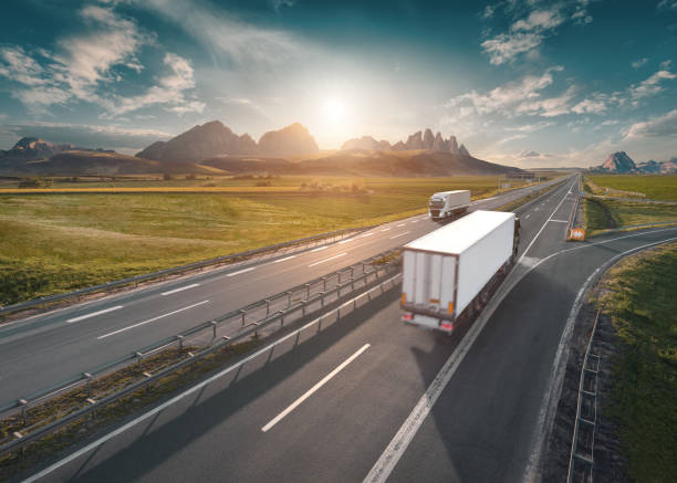 istock Two lone white trucks on highway at idyllic sunny morning 680106048