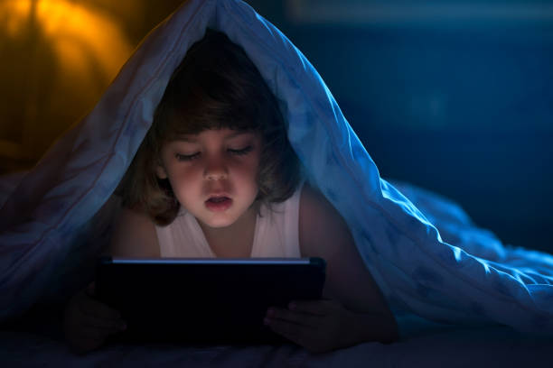 istock Little boy watching cartoons at night 680111278
