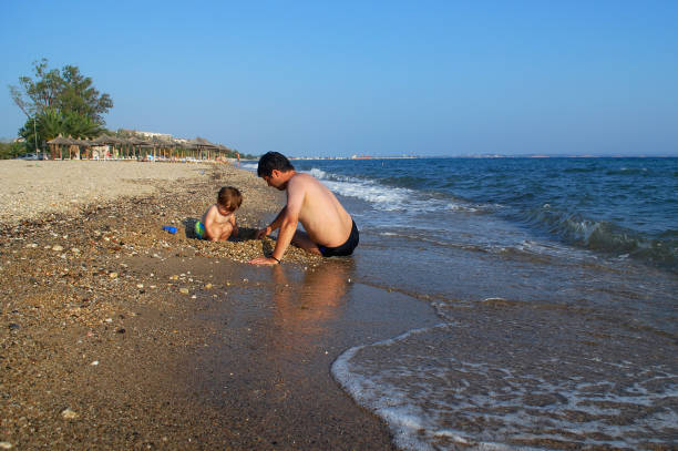 istock Father and son play on the beach 680117622