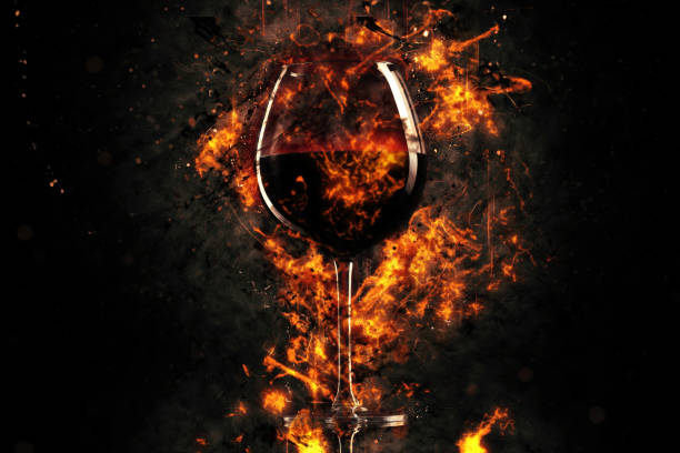 red wine glass into the fire stock photo