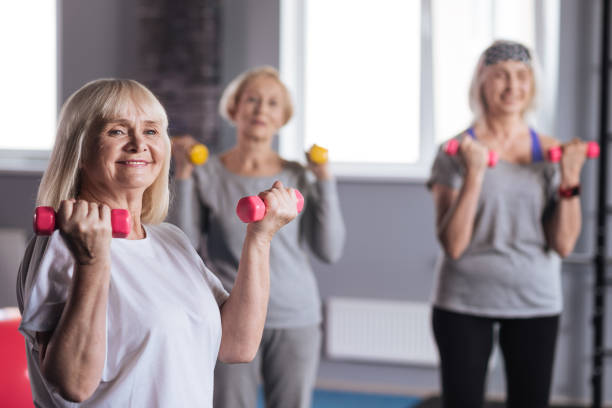 istock Happy strong woman standing with dumbbells 680144762