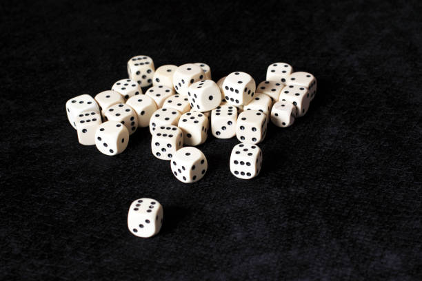 A handfull of white dice placed on a black background